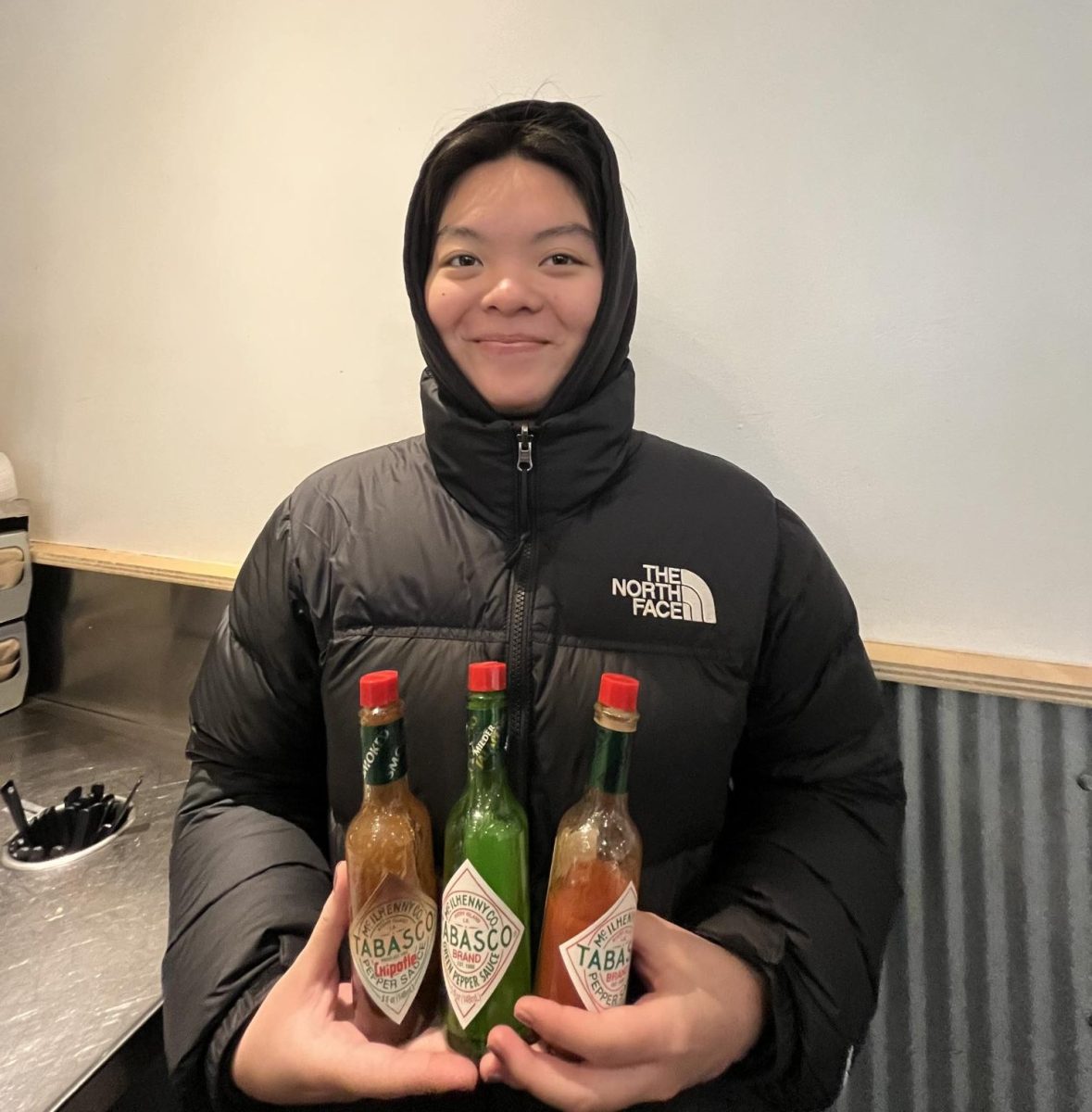Senior, Claris Ie, posing with a variety of hot sauces. 