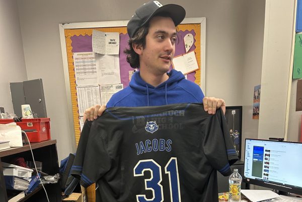 Jacobs holds up the shirt he wears to the teams games.