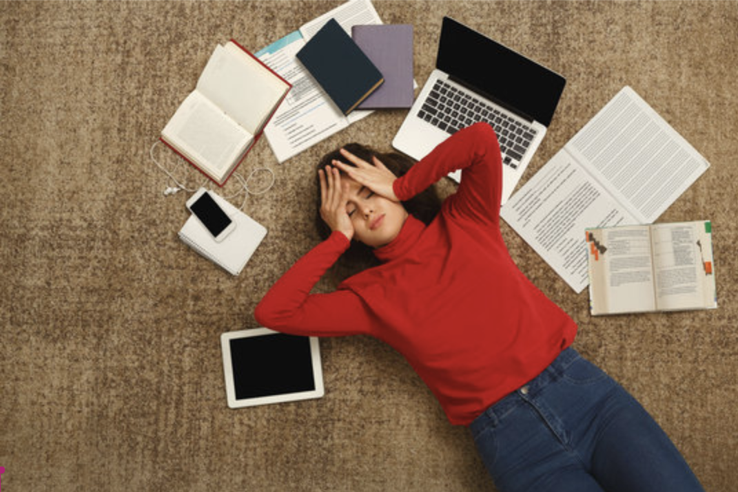 Tired Student Girl Lying On The Floor With Books And Gadgets. 
courtesy of Stock images