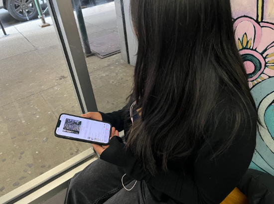 A Baruch student listening to music in the lobby.