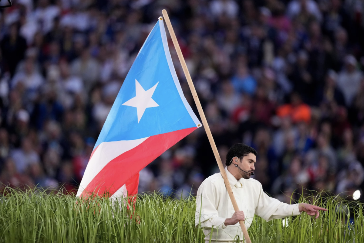 Bad Bunny carries Puerto Rico's flag across stage.